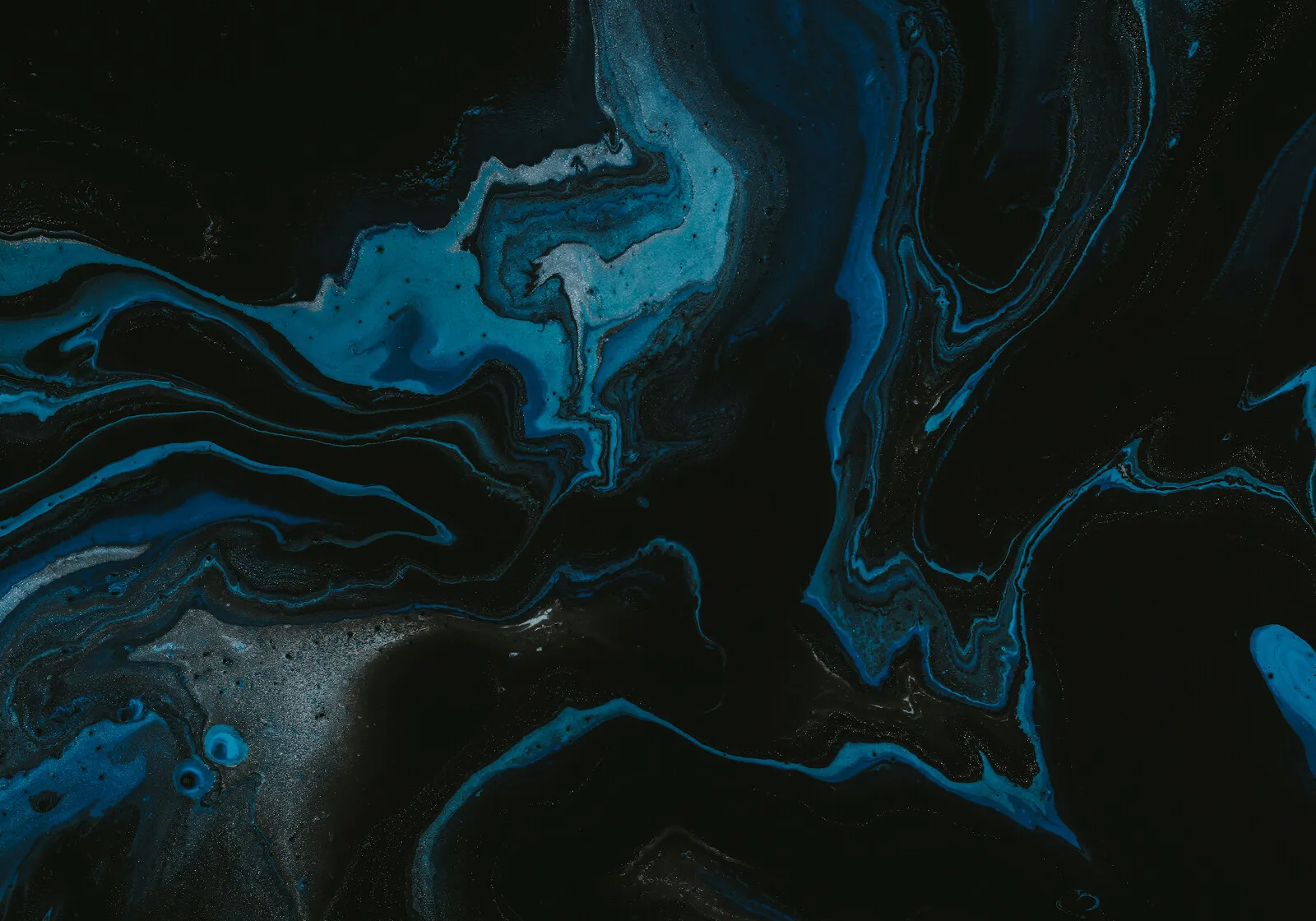 Abstract dark art with swirling blue and black fluid patterns resembling marble or liquid.