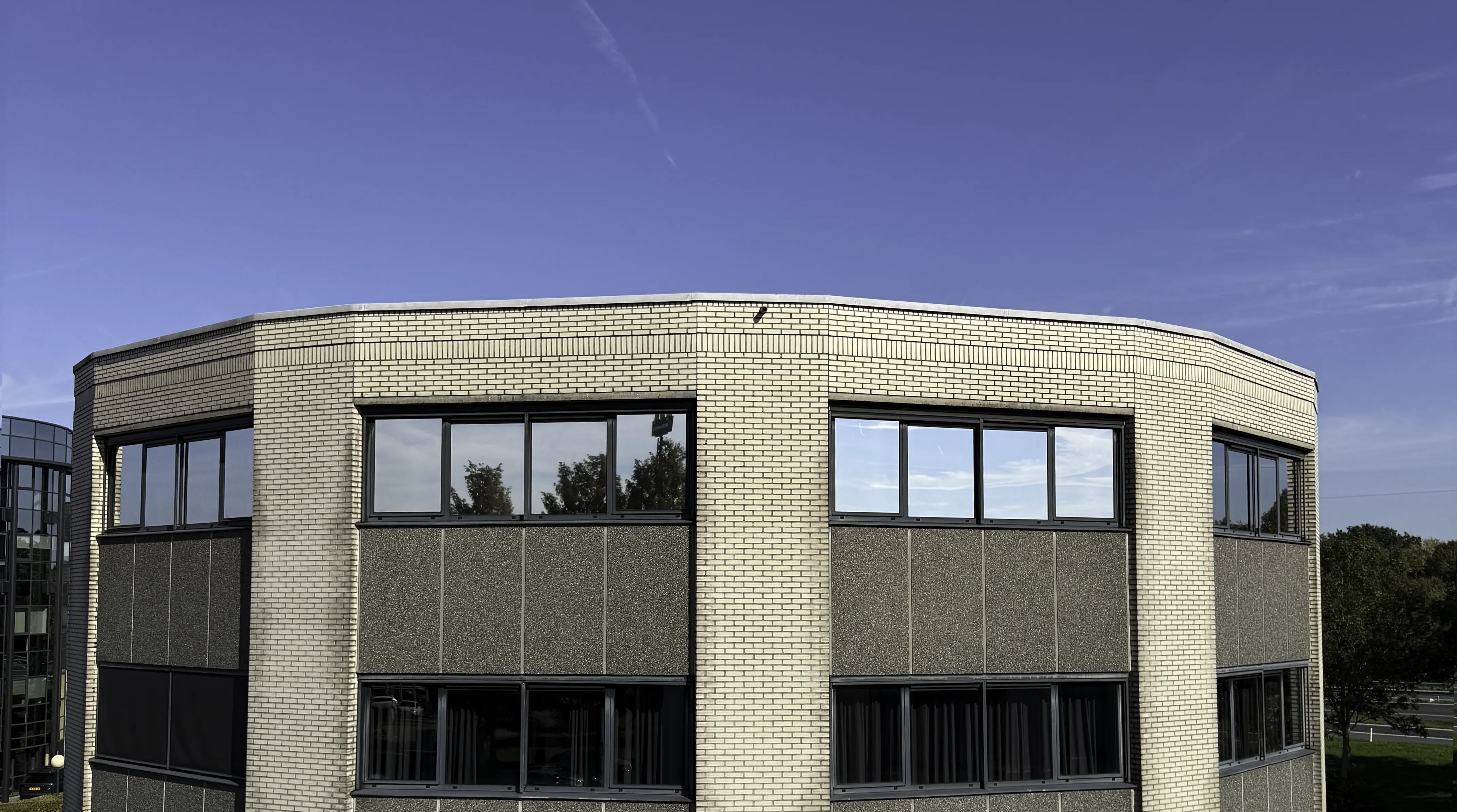 Zonwerende raamfolie op de gevelbeglazing van een bedrijfspand in Meppel