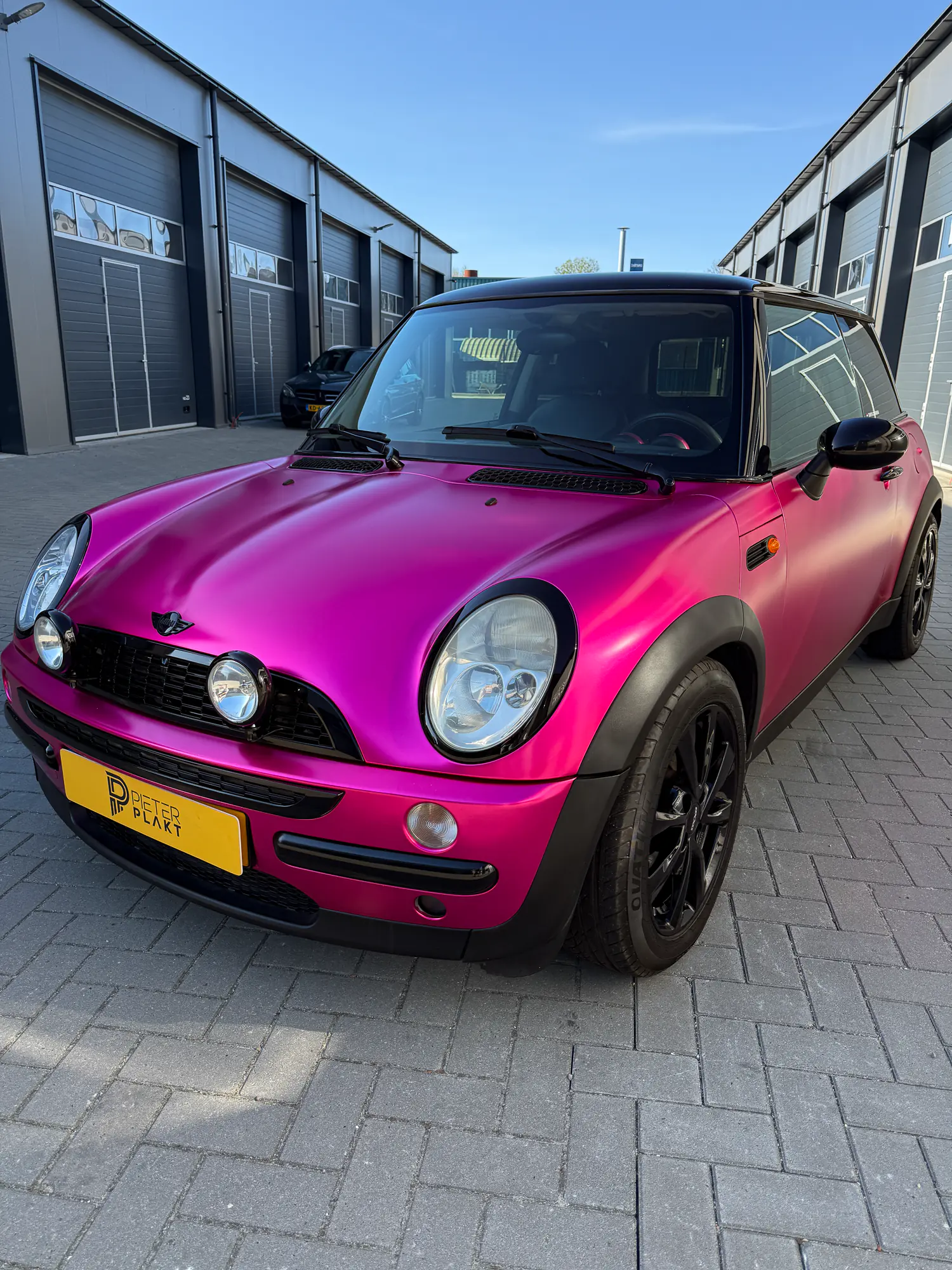 Gewrapte Mini Cooper in satijnchroom roze bij de werkplaats in Burgum