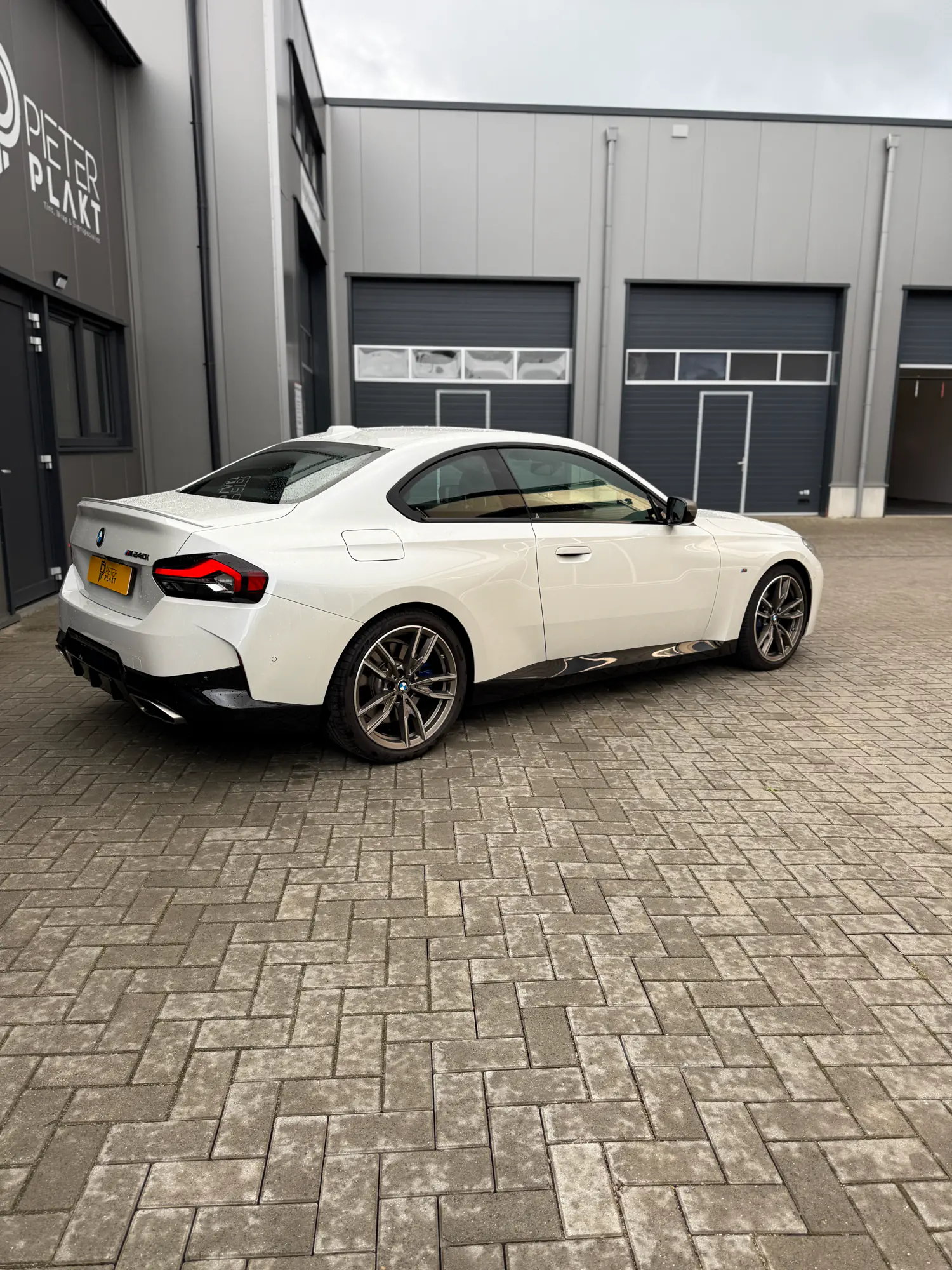Het uitrakelen van de folie op een zijruit van de BMW 240i