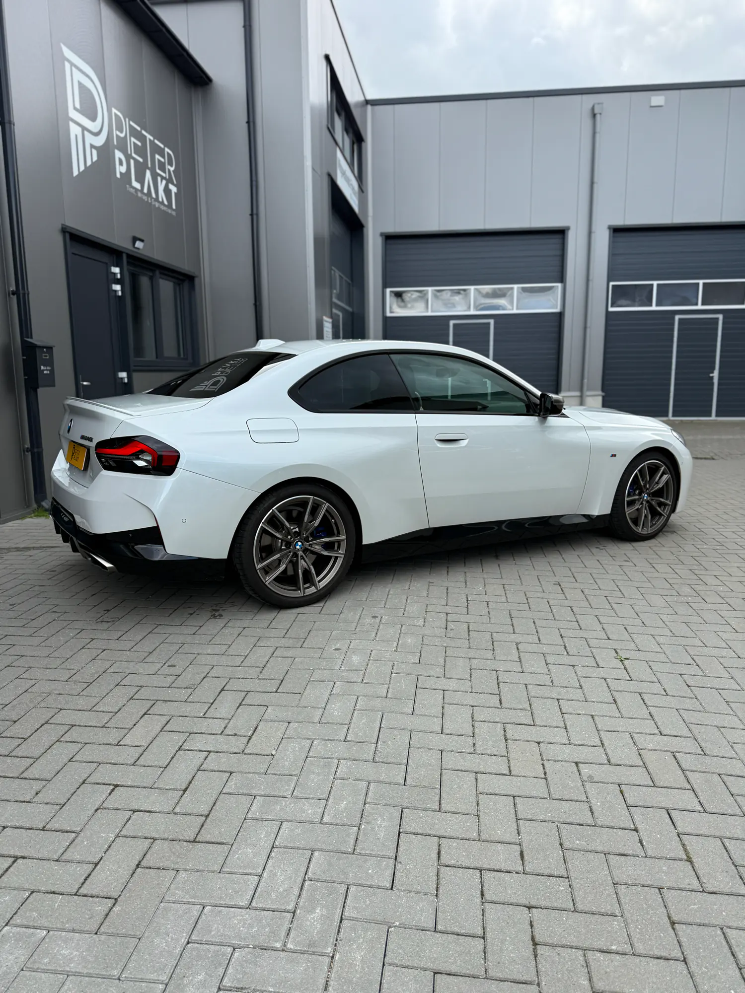 Zijaanzicht van de BMW 240i met geblindeerde ruiten