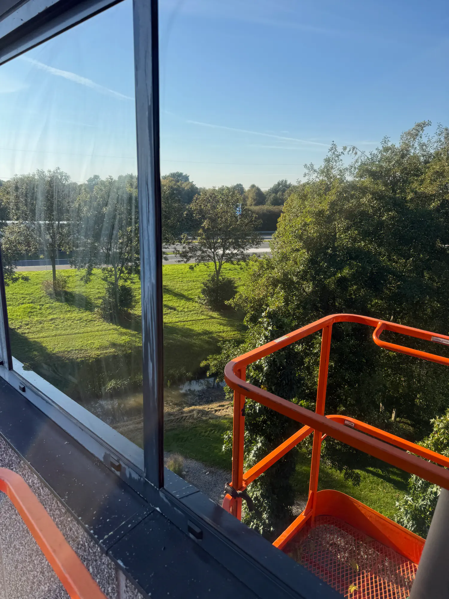 Het aanbrengen van zonwerende folie vanuit de hoogwerker