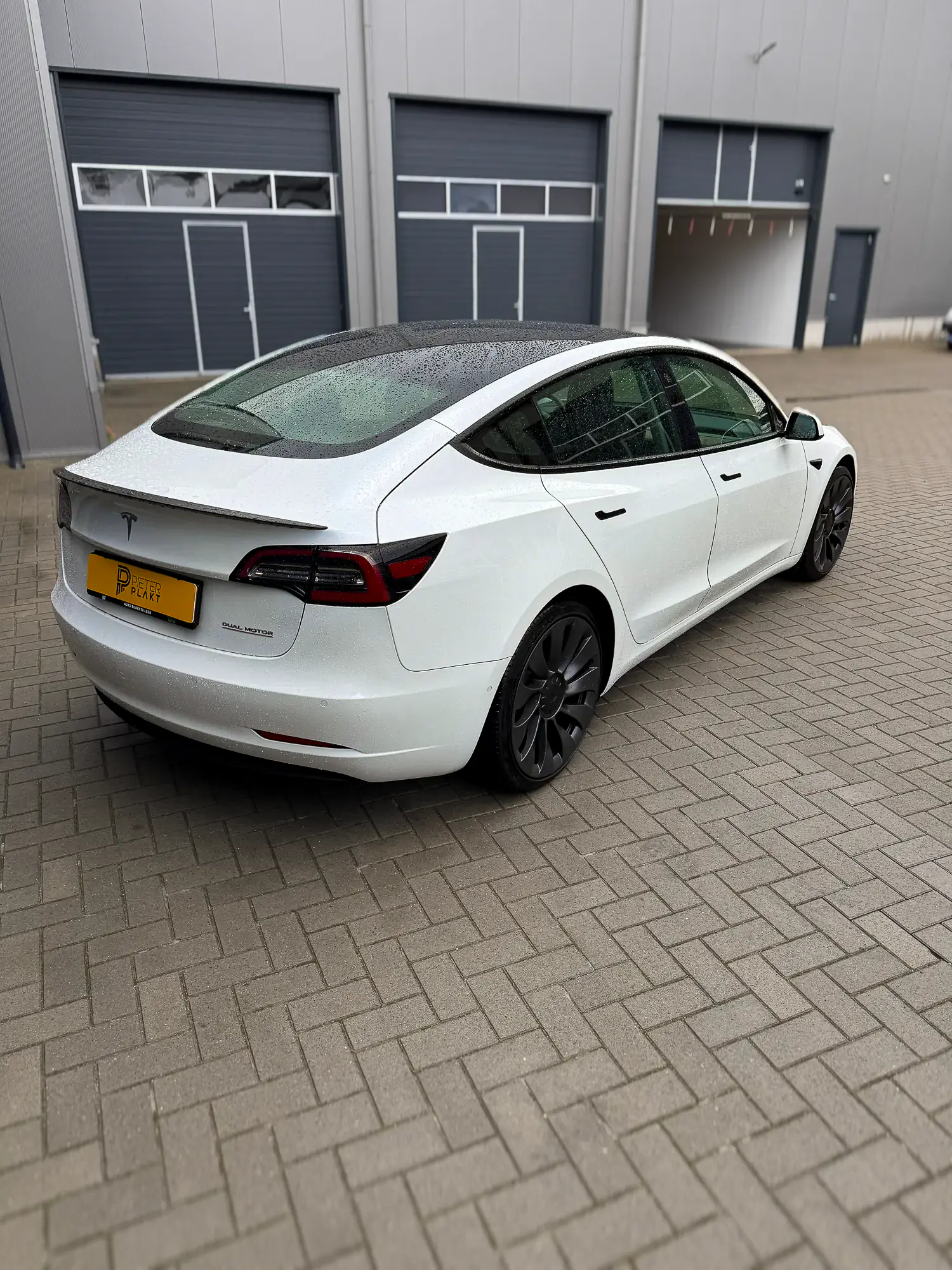 Witte Tesla Model 3 met heldere ruiten, voor het blinderen