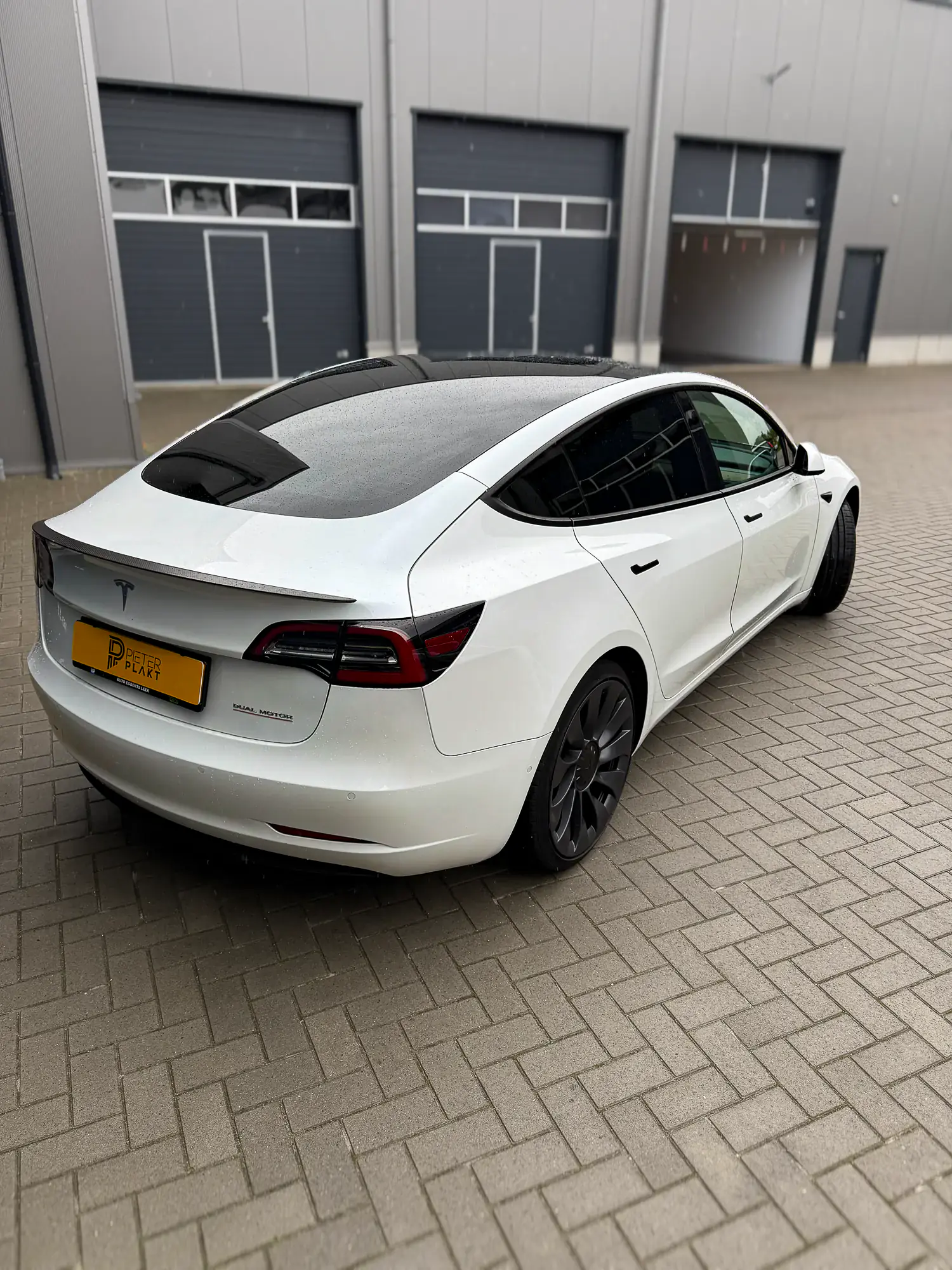 Witte Tesla Model 3 na het blinderen, zijaanzicht