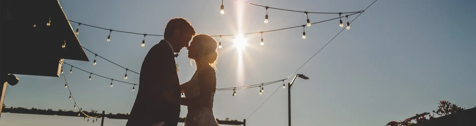 Couple kissing with the sun shining behind them
