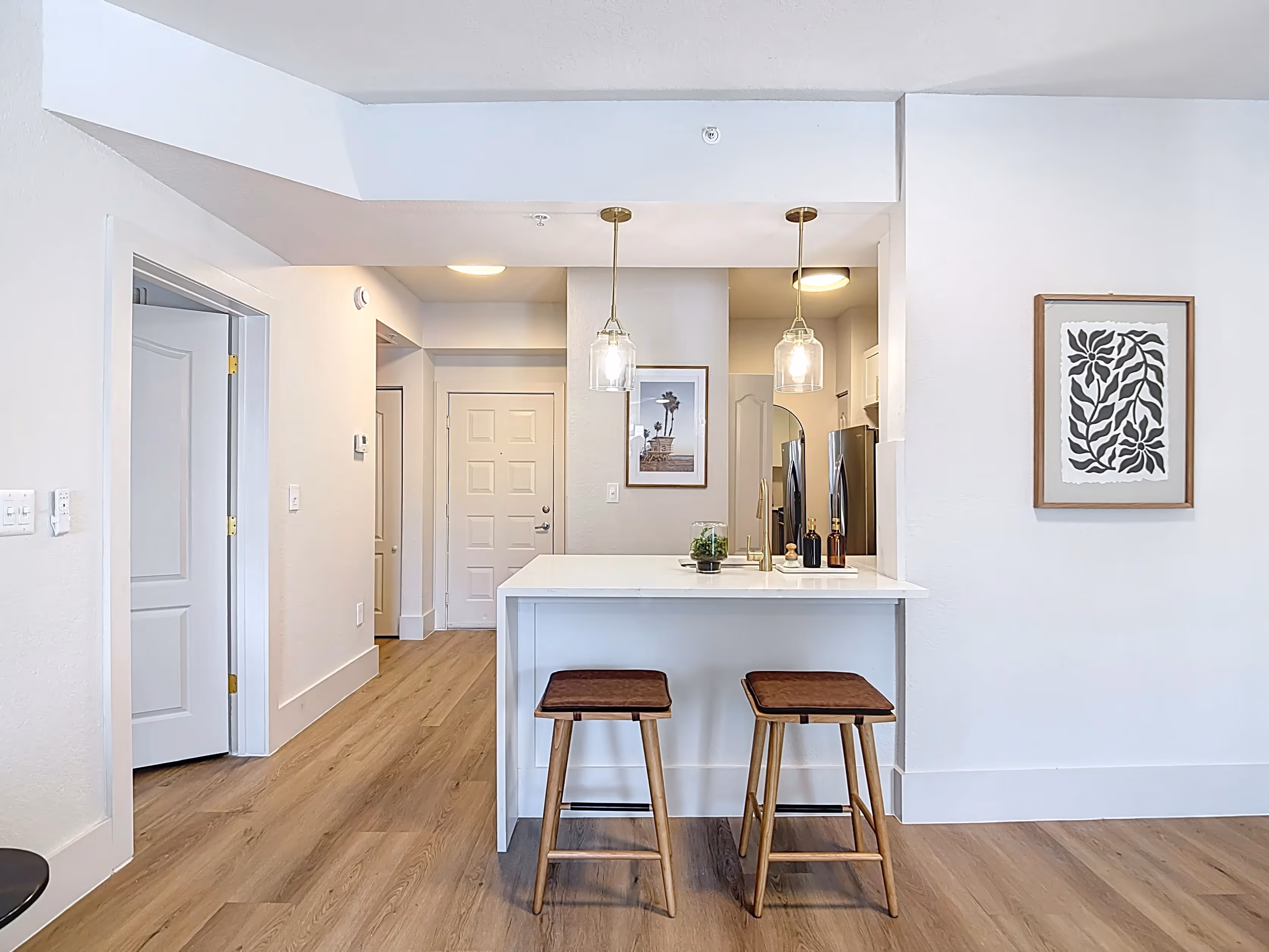 Wide view of living area with sofa, tv, and coffee table and view into dining area and kitchen