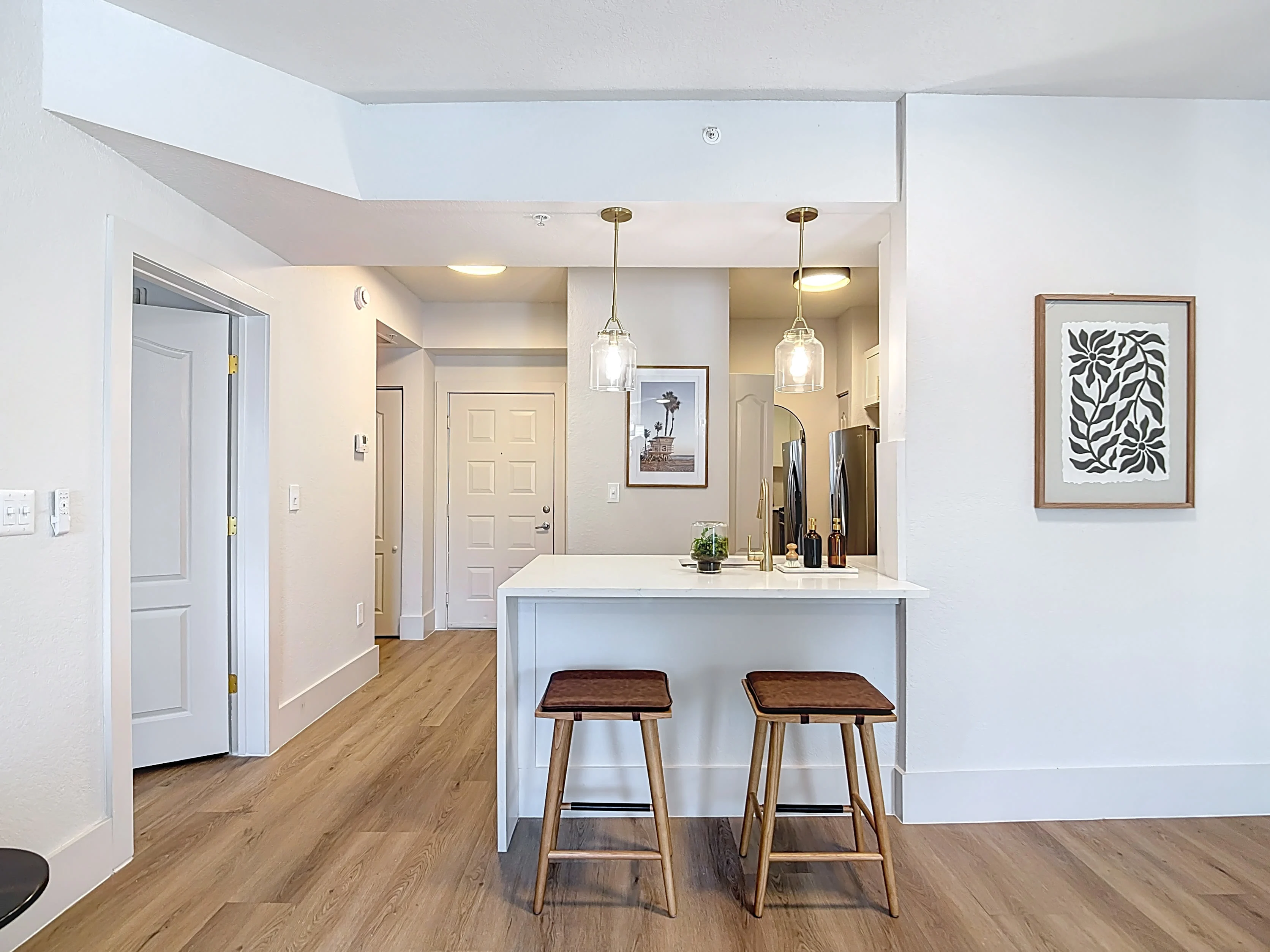 Wide view of living area with sofa, tv, and coffee table and view into dining area and kitchen