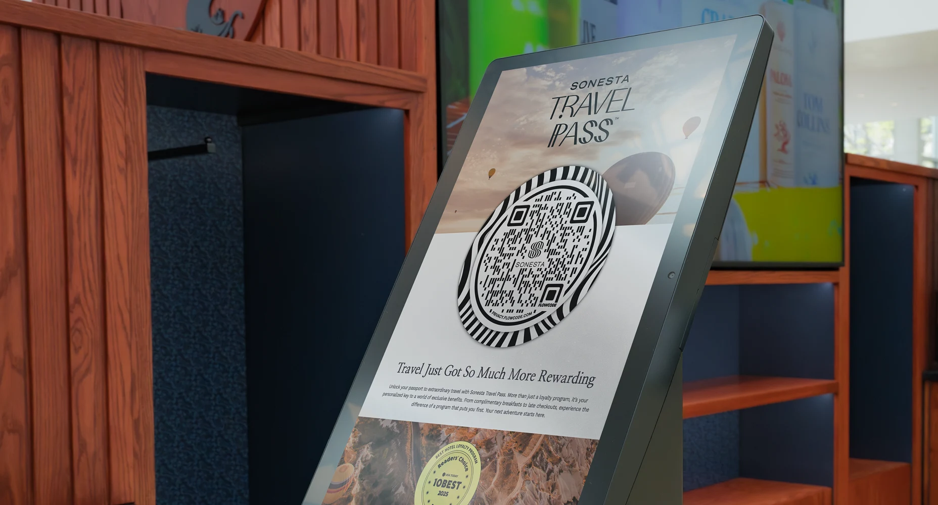 Digital display presents Sonesta Travel Pass Flowcode and text about travel rewards and loyalty benefits.