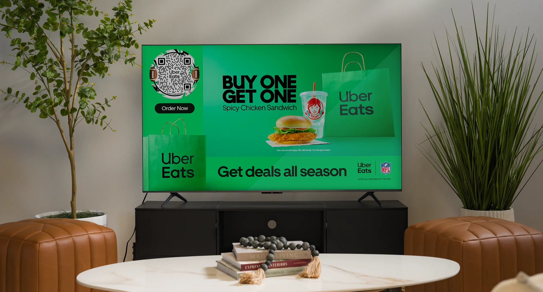TV screen showing Uber Eats ad for buy one get one spicy chicken sandwich deal with Flowcode and Wendy's drink.