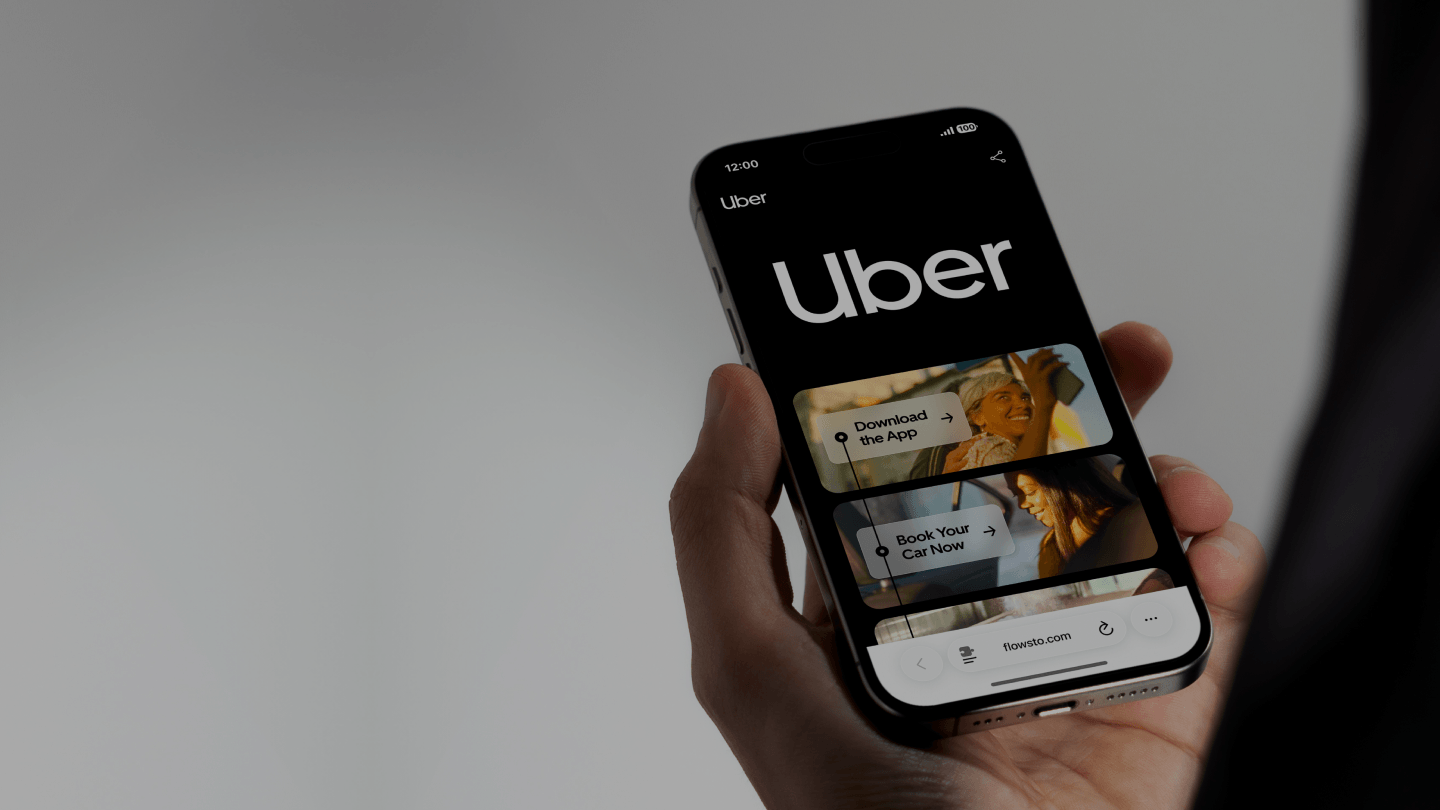 Hand holding a smartphone displaying Uber FlowHub interface with options to download the app and book a car.