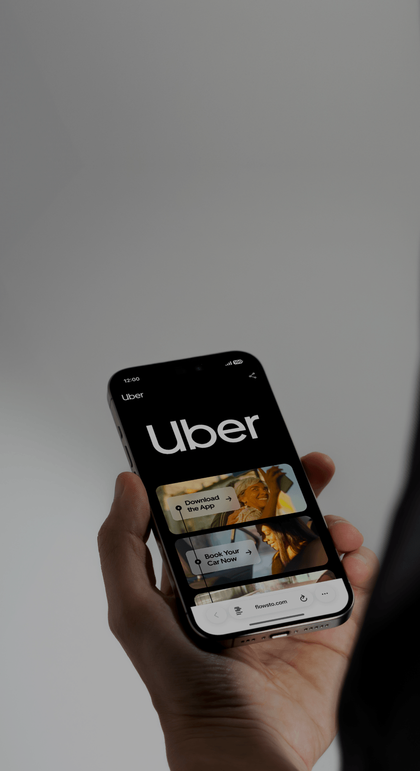 Hand holding a smartphone displaying Uber FlowHub interface with options to download the app and book a car.