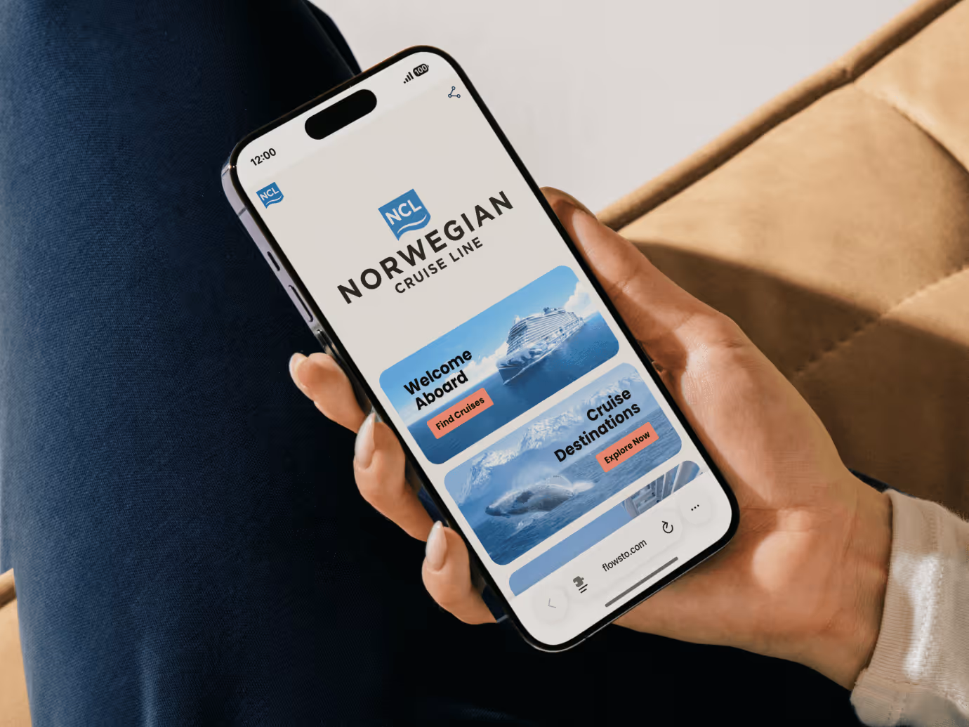 Hand holding a smartphone displaying Norwegian Cruise Line FlowHub with options to find cruises and explore destinations.