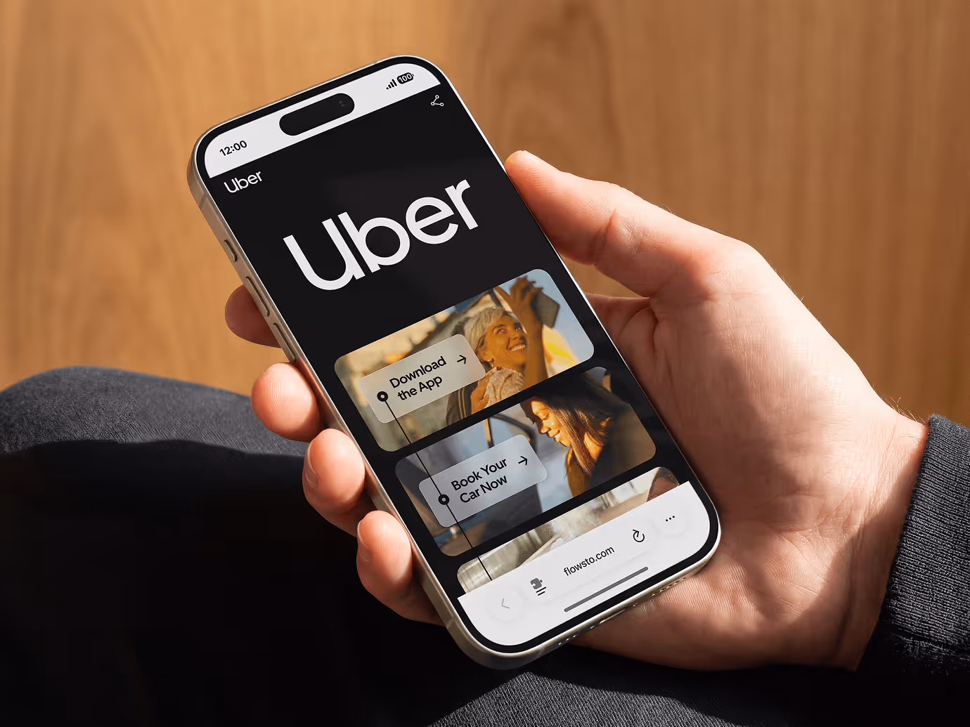 Hand holding a smartphone displaying Uber FlowHub interface with options to download the app and book a car.