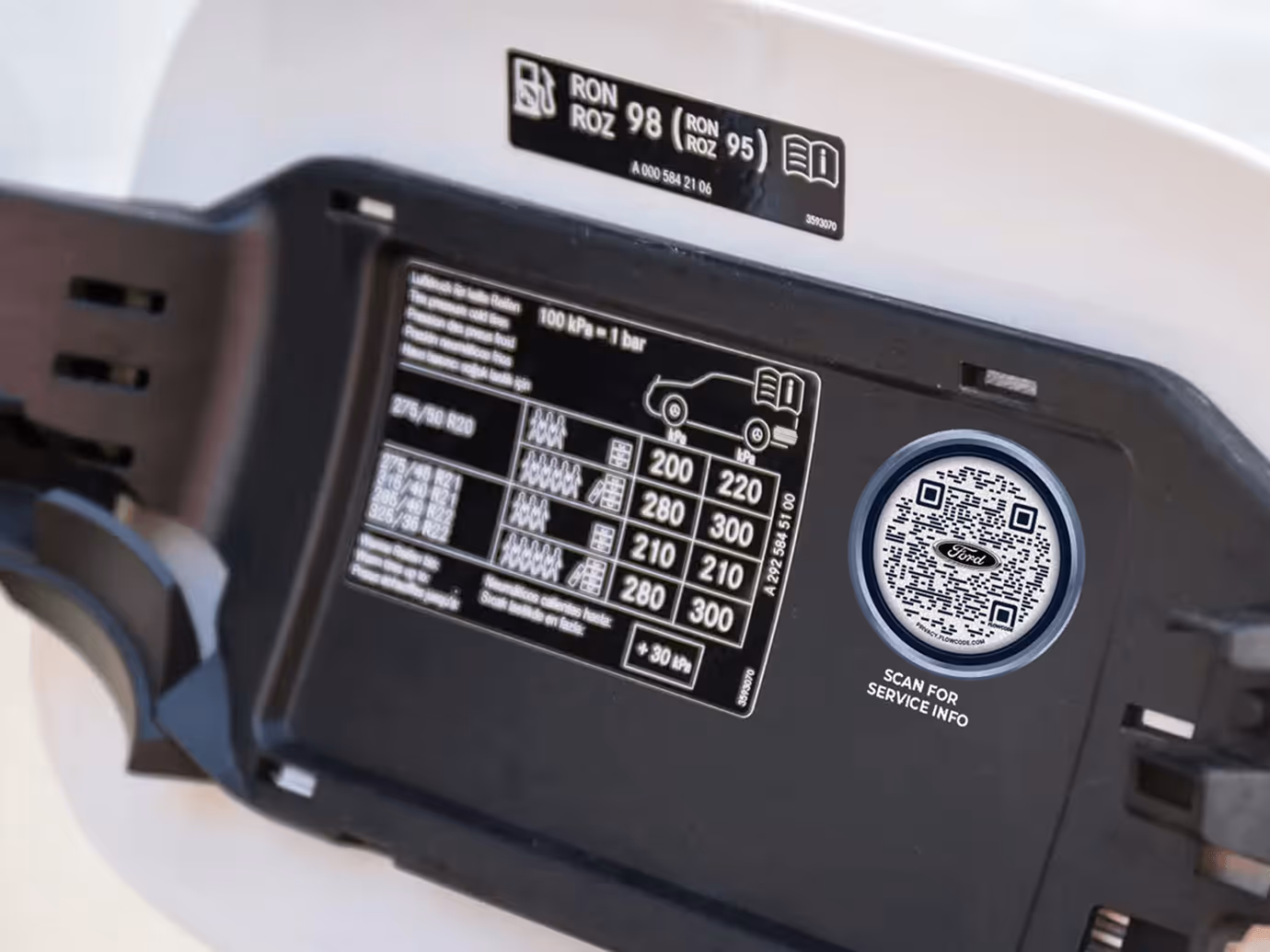 Vehicle fuel door interior showing tire pressure chart and a Flowcode labeled 'Scan for service info' with Ford logo.