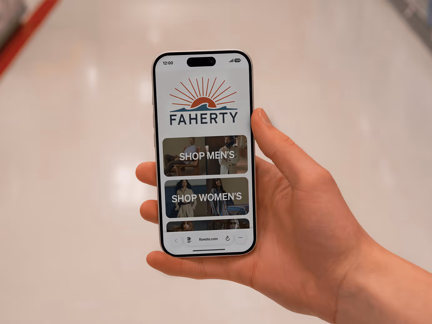 Hand holding a smartphone displaying Faherty FlowHub with options to shop men's and women's collections.