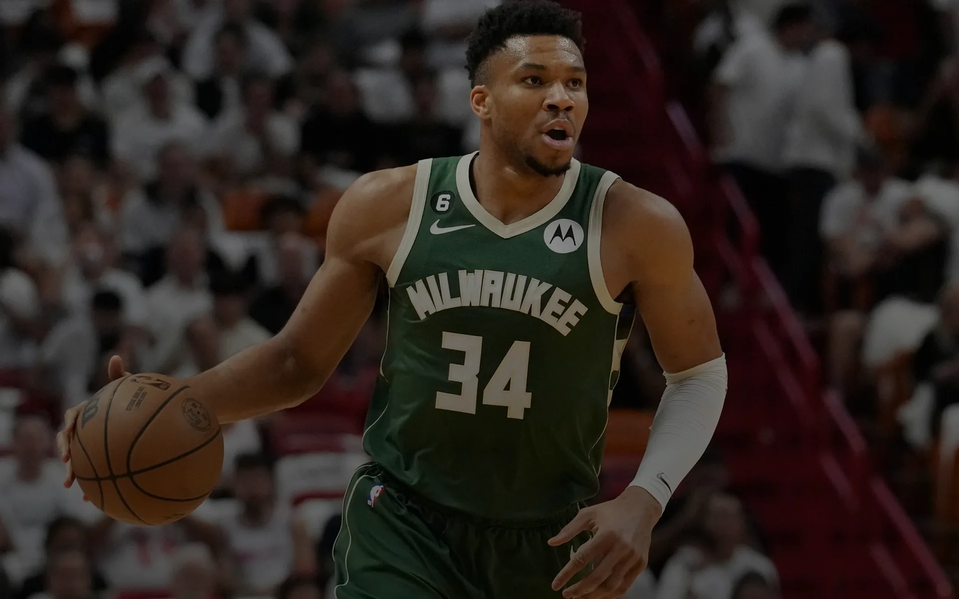 Milwaukee Bucks basketball player wearing number 34 dribbling a basketball during a game.