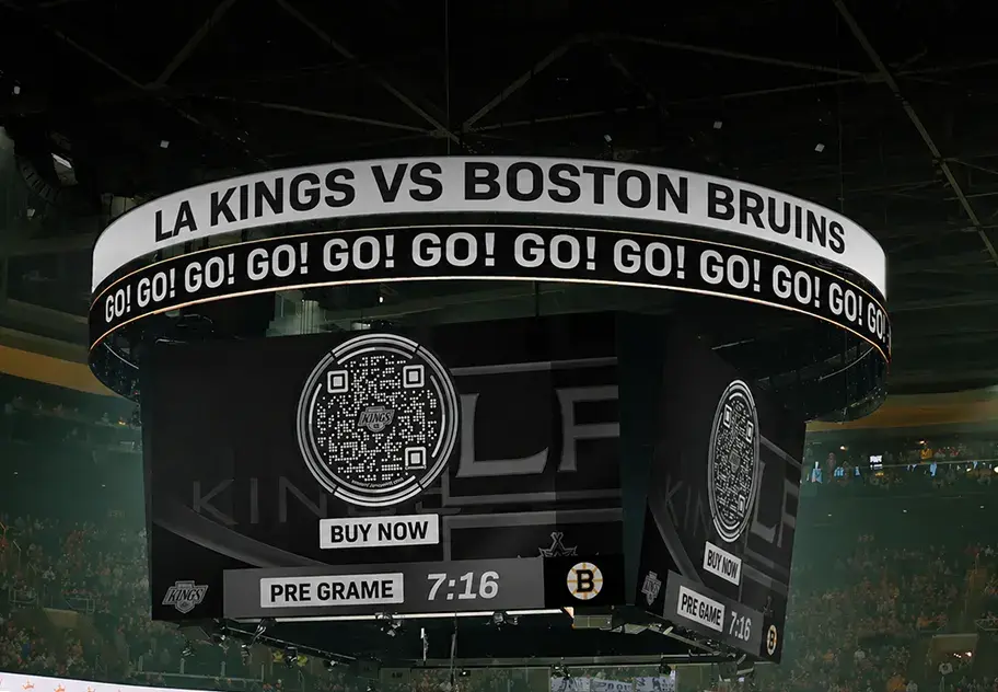 Arena scoreboard showing LA Kings vs Boston Bruins with a Flowcode for buying tickets and countdown timer at 7:16.
