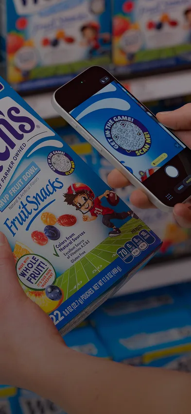 A Welch's Fruit Snack box is being scanned in shopping aisle at grocery store.