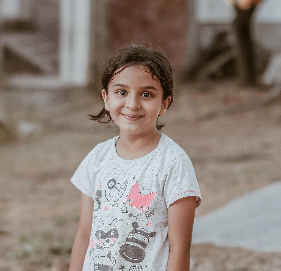 Girl in a graphic t-shirt standing outdoors