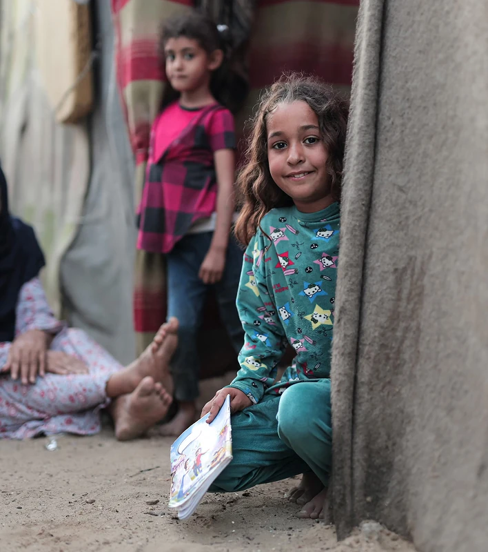 Children in a doorway, one smiling in the foreground