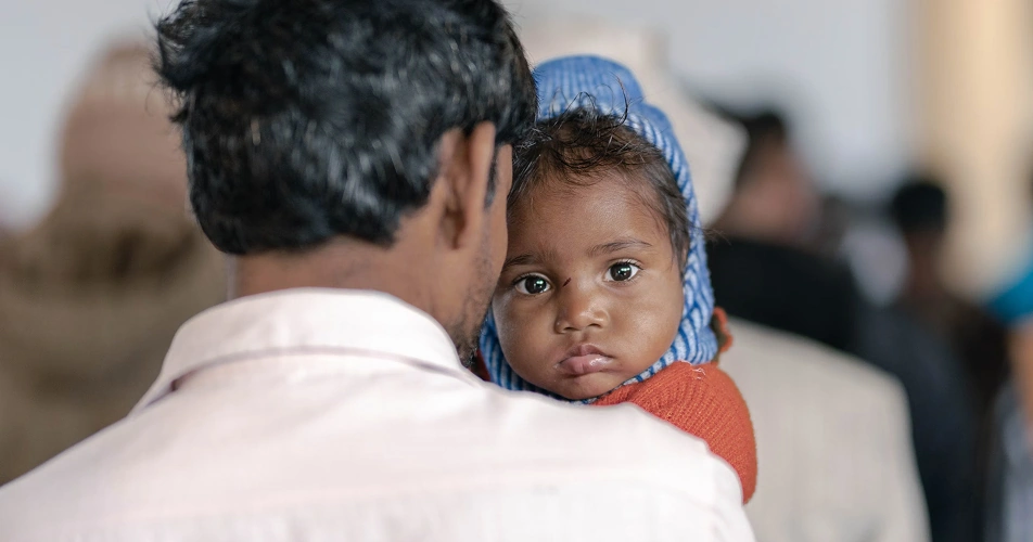 Father holding his daughter after receiving support from Karuna's family programs