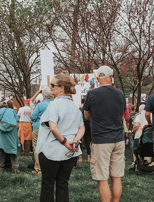Man and woman standing together at an outdoor community event, representing organizational partnership