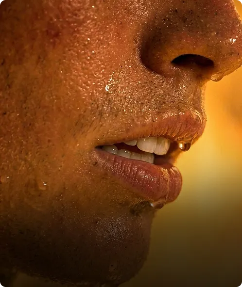 Close-up of a person’s lower face with sweat and a drop hanging from their nose.