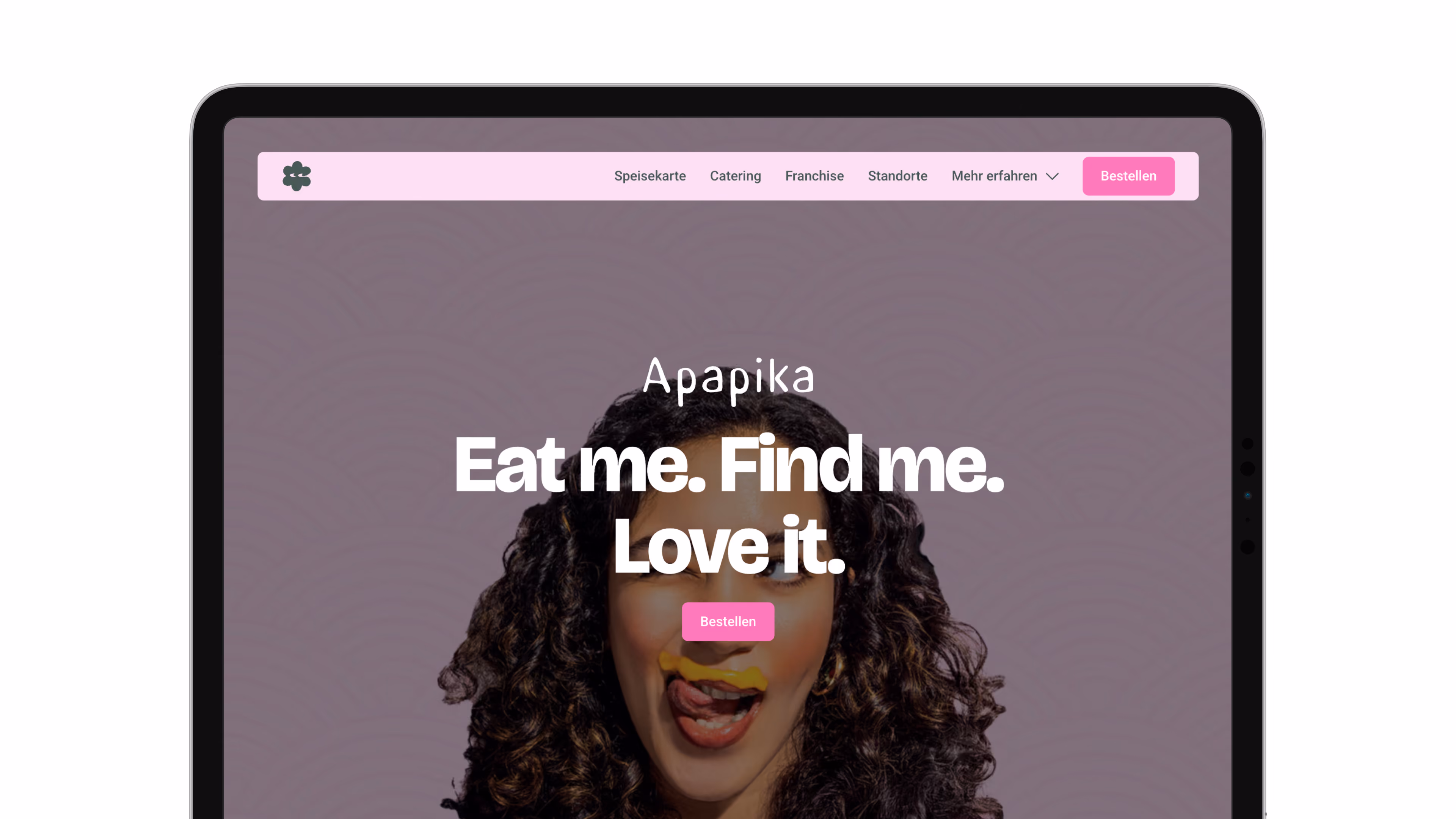 Website-Mockup mit einer lächelnden Frau mit lockigem Haar und einem markanten Schriftzug – „Apapika: Eat me. Find me. Love it.“ – in verspieltem, lebendigem Stil.
