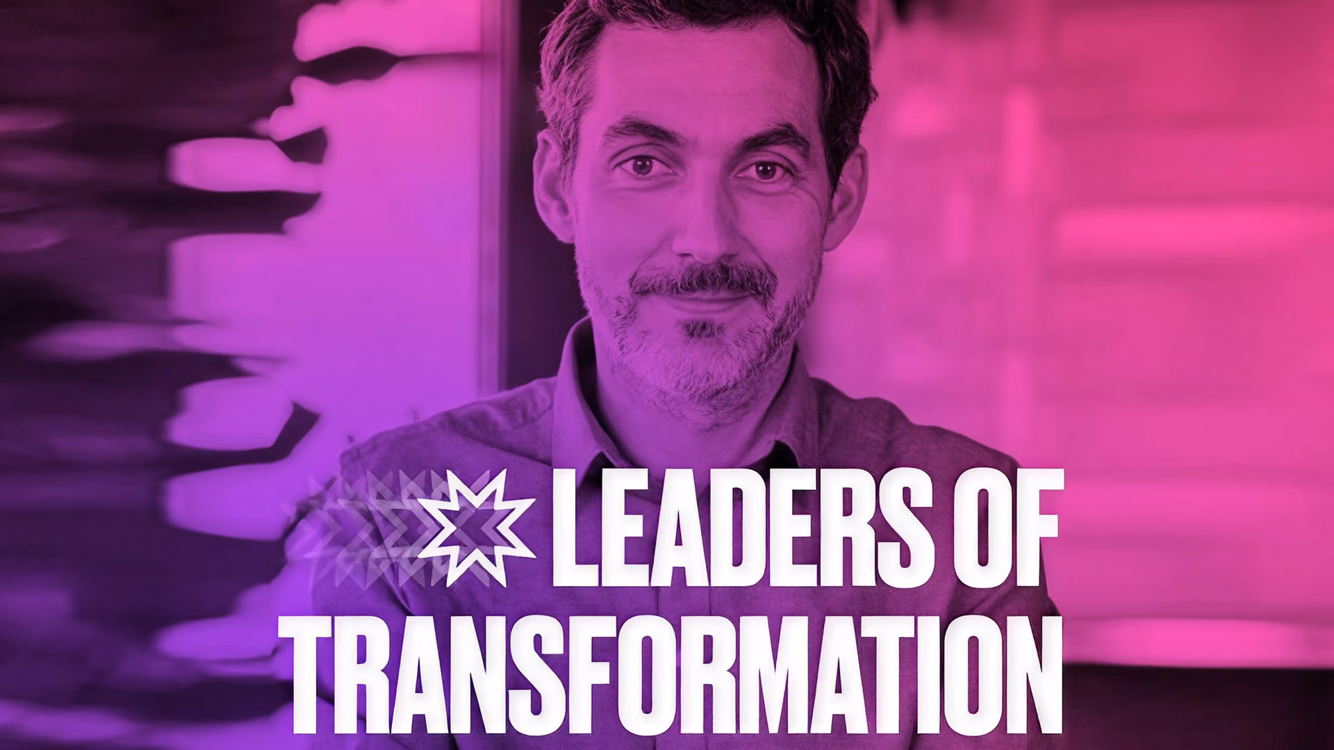 Violett getöntes Porträt eines lächelnden Mannes mit markantem weißem Schriftzug „Leaders of Transformation“, der Zuversicht und Inspiration vermittelt.