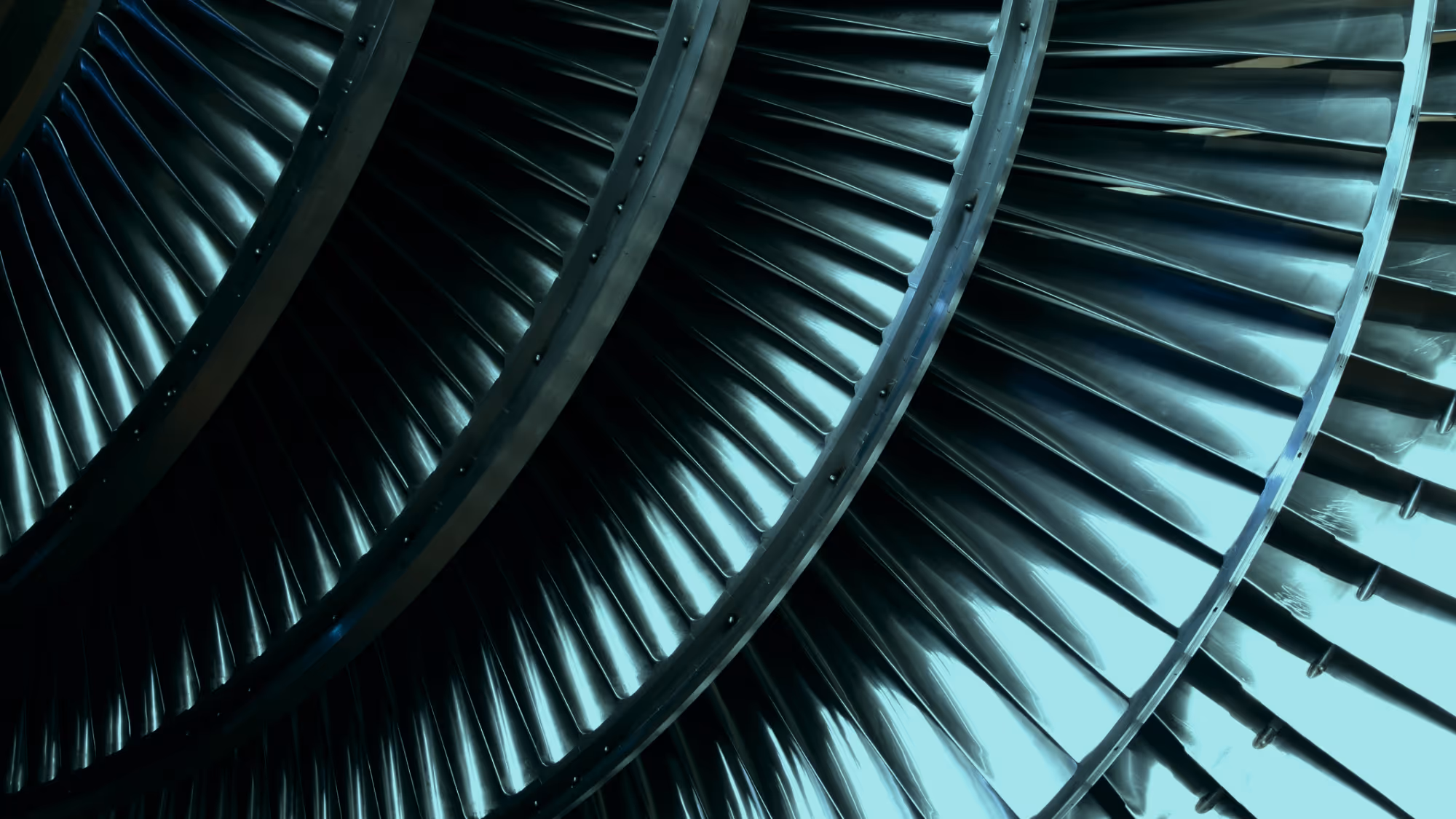 Close-up of metallic turbine blades arranged in concentric circles.