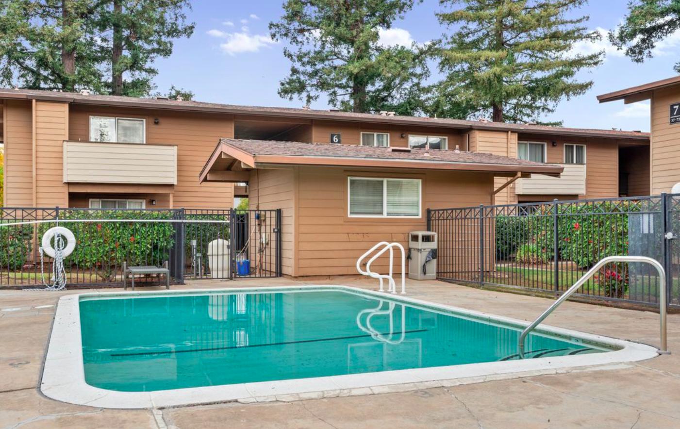 Swimming pool with apartment building in background.