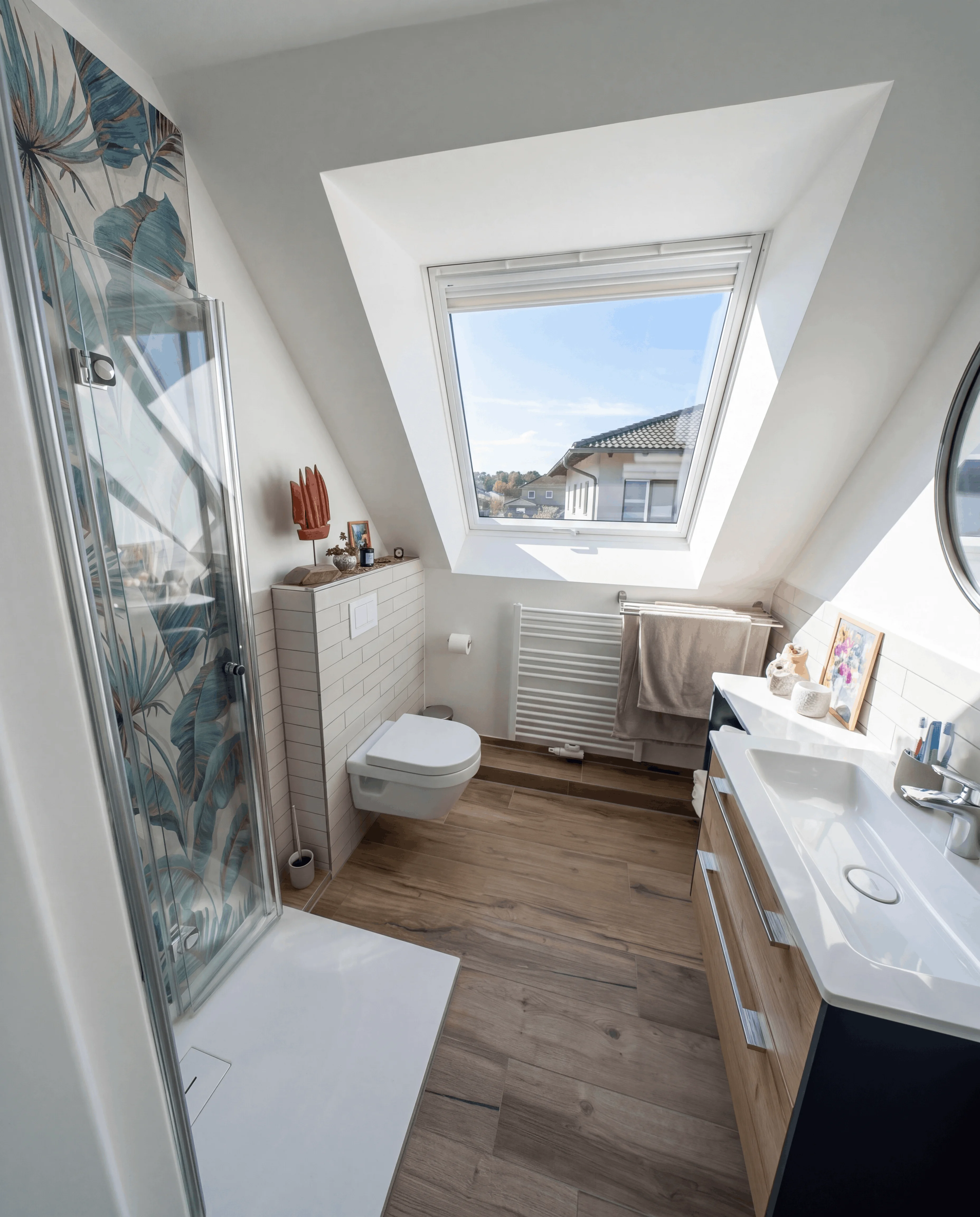 Modernes Badezimmer mit Dusche, hängendem WC, Dachfenster und Holzfußboden.