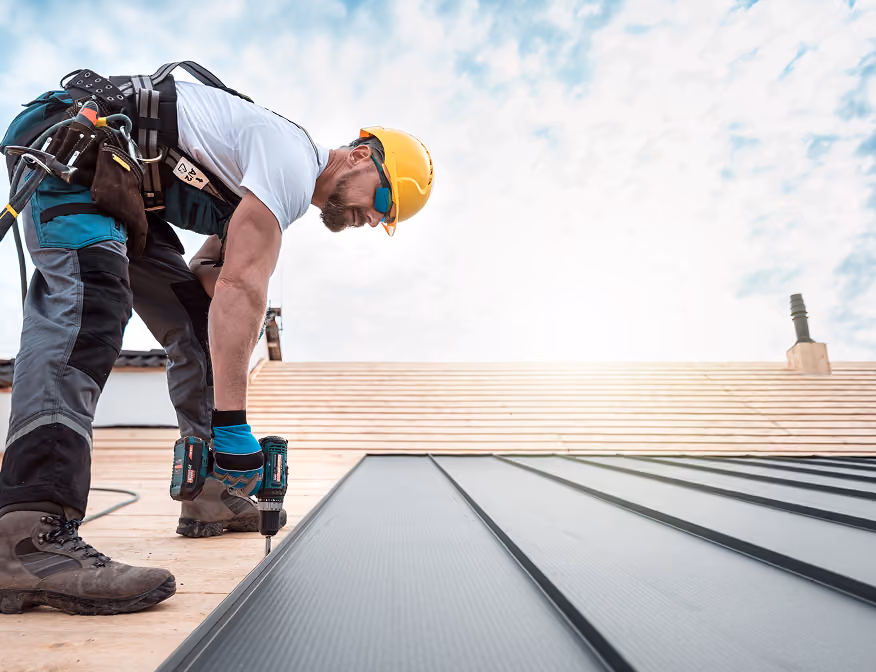 Roofer securing roofing materials during construction at a commercial roofing job.