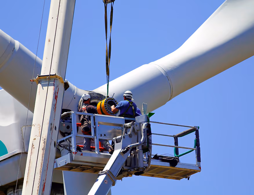 Two men in wind power careers conducting maintenance on a wind turbine.
