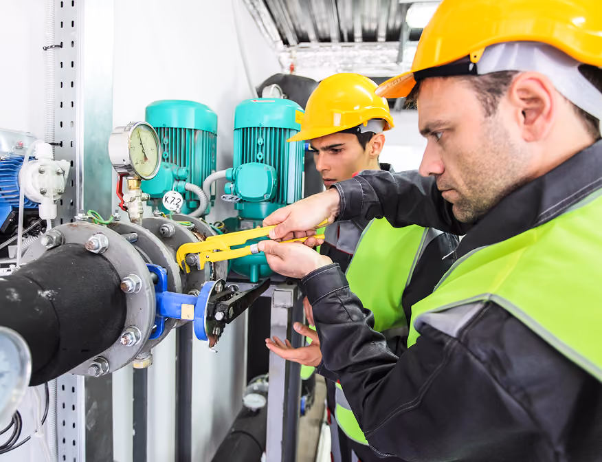 Two plumbers at an industrial pipefitting job in California.