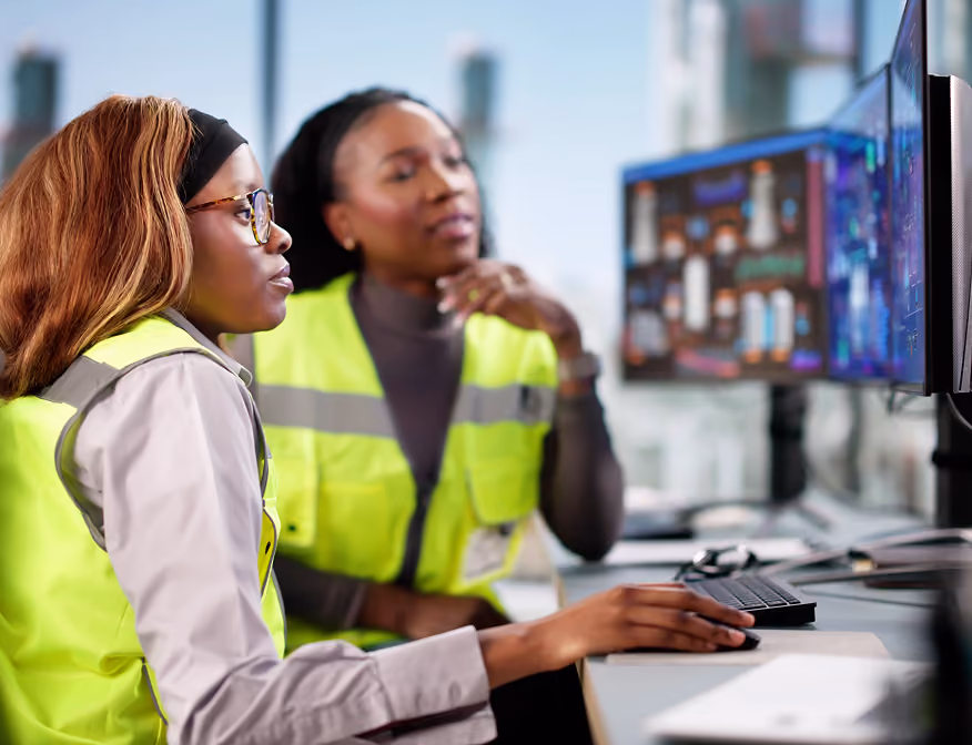 Two women in energy analyst positions working with digital data to support clean energy planning and operations.
