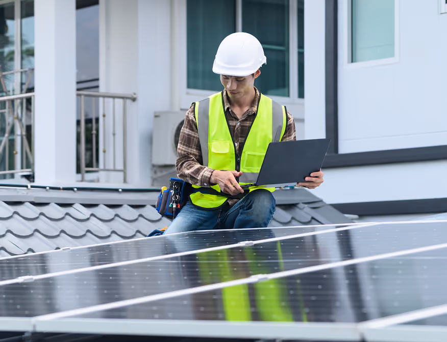 Solar energy auditor checking residential solar panel system performance on a home roof.
