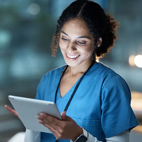 Healthcare worker smiling and looking at a tablet