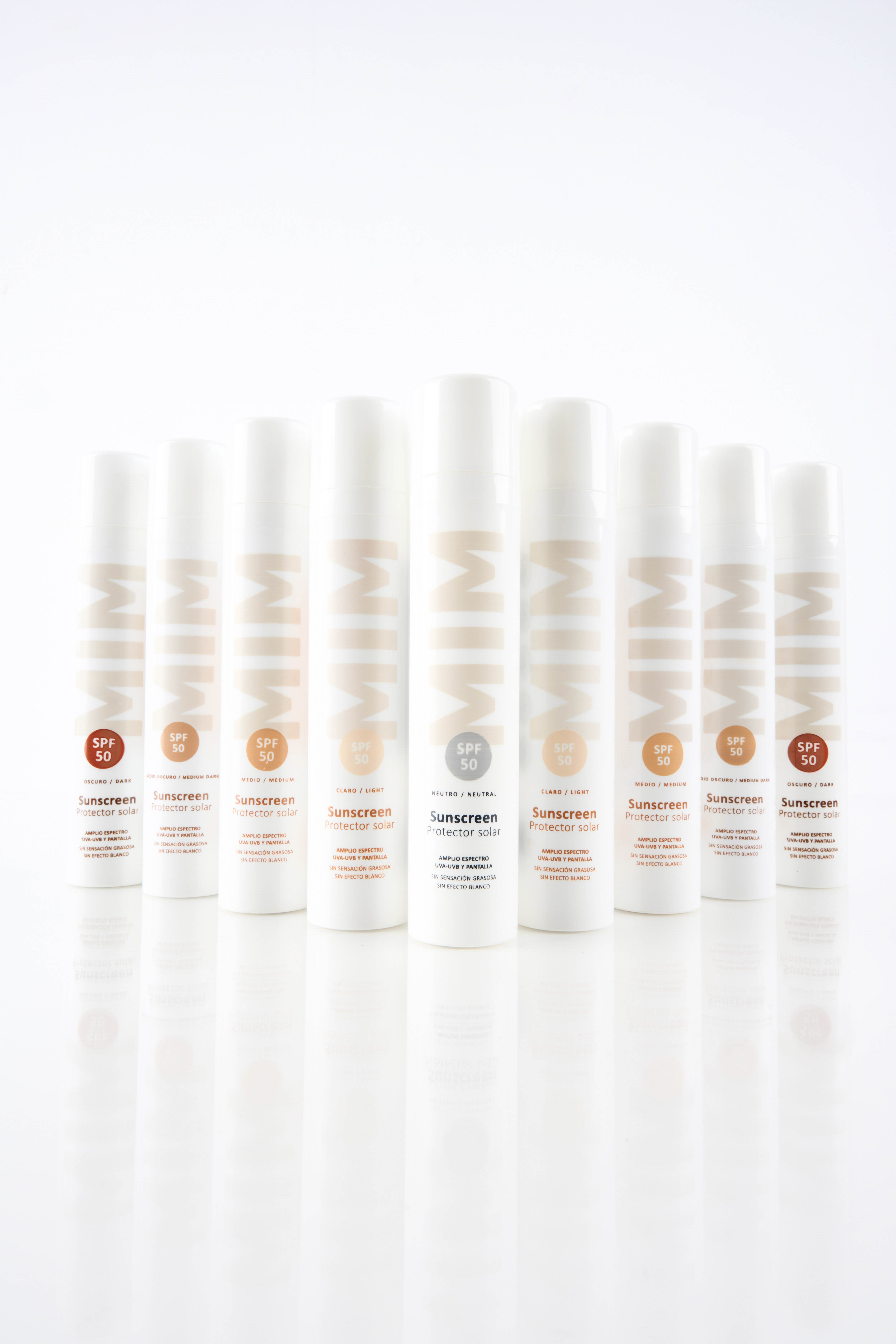 Full-range product photography by Gooper: MIM SPF 50 sunscreen in nine shades, lined up to showcase the complete shade range for a beauty catalog.