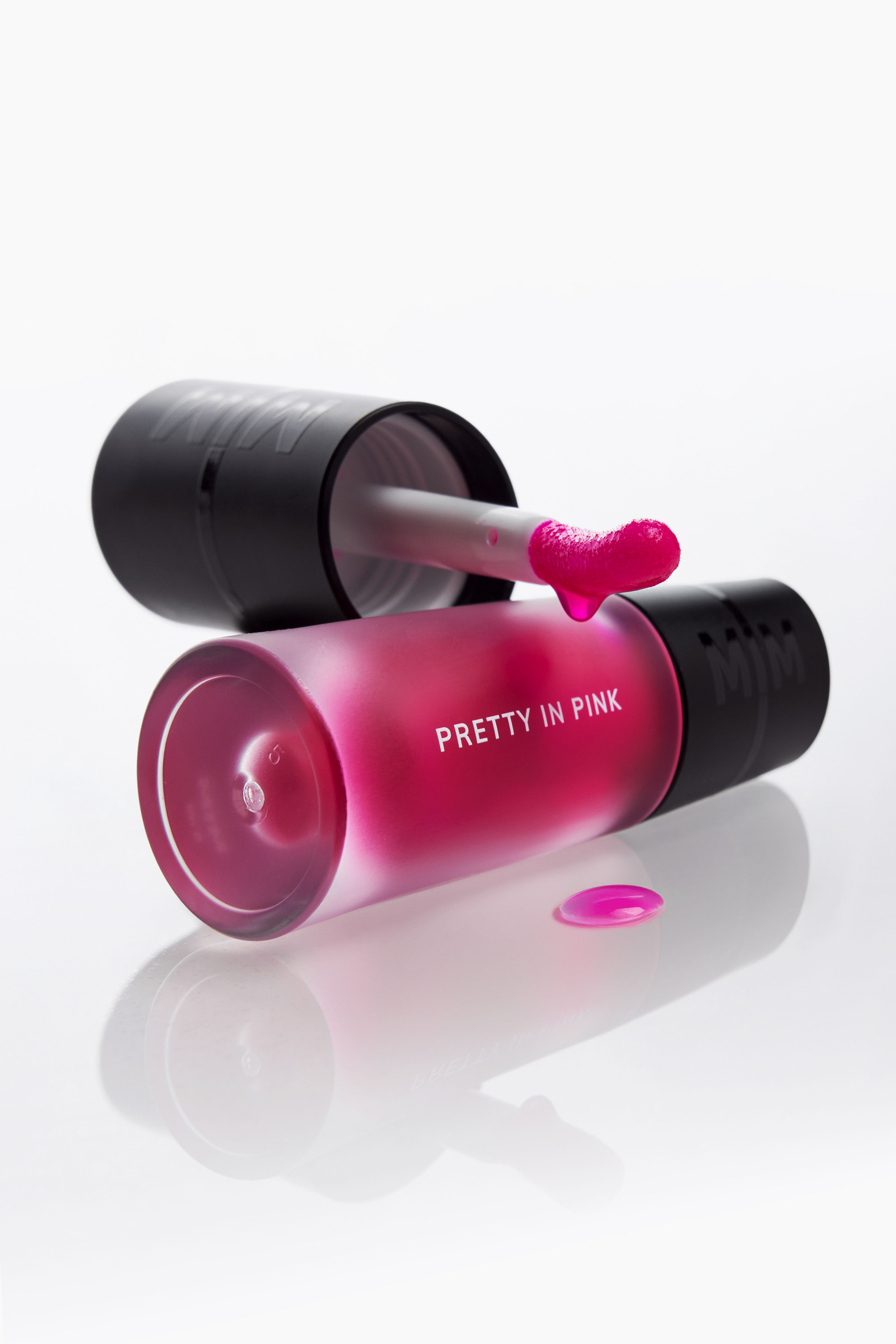 Product photography by Gooper with a drip effect: MIM Pretty in Pink lip gloss and its doe-foot applicator, shot for a beauty brand.
