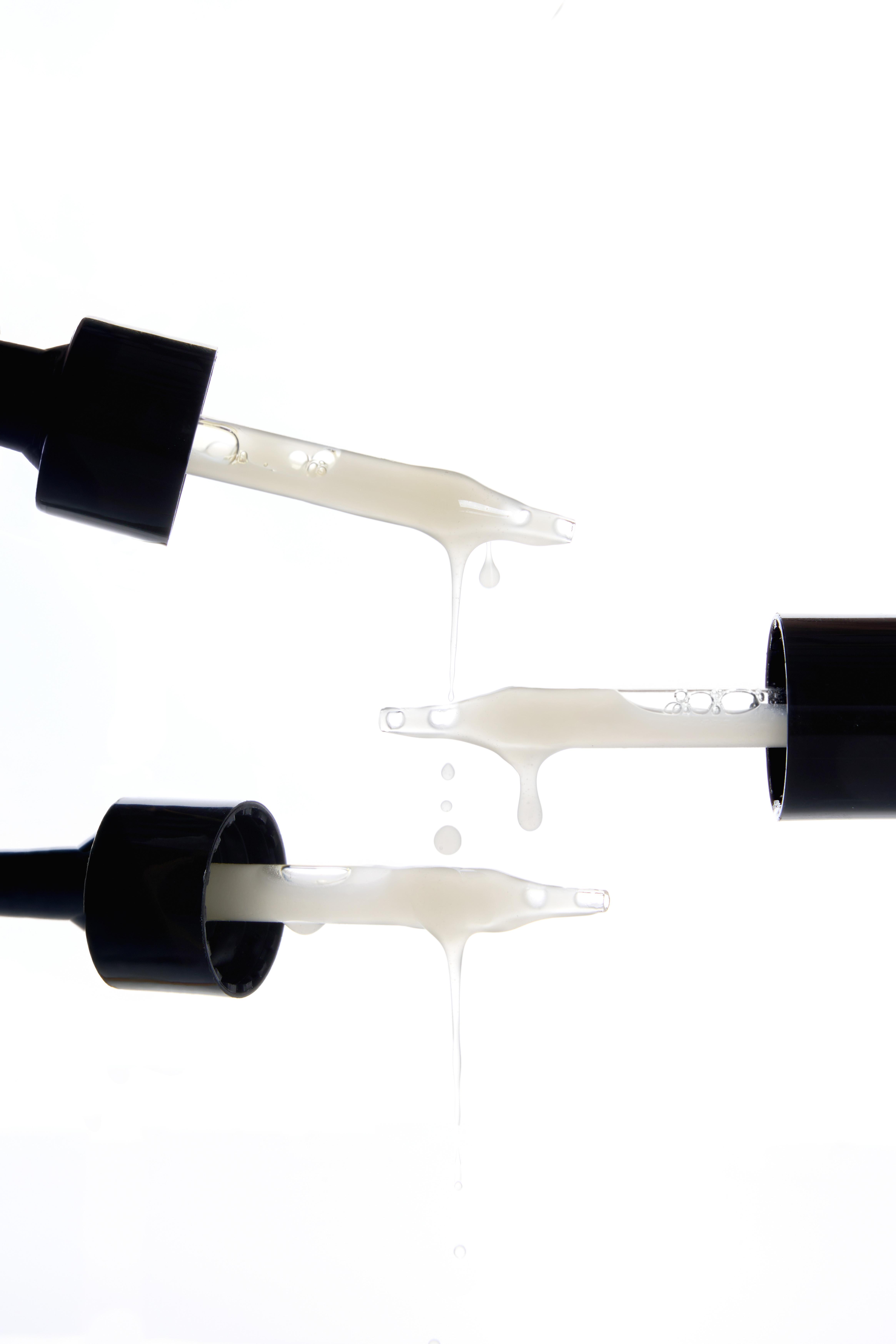 Macro product photography by Gooper: MIM doe-foot applicators dripping formula on white, highlighting texture for beauty e-commerce.