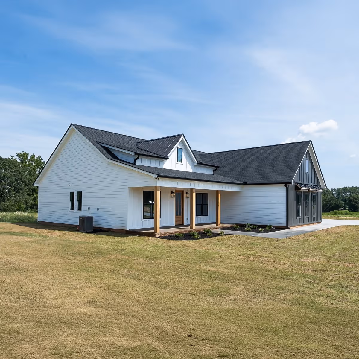 Modern single-story white house with black roof, wood accents, and a small front porch on a grassy lawn.