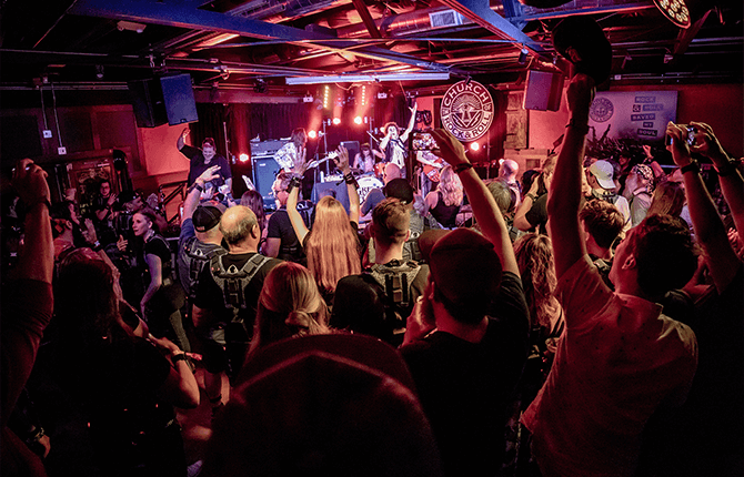 Audience wearing Music: Not Impossible haptic suits raises their hands during an immersive live concert experience.