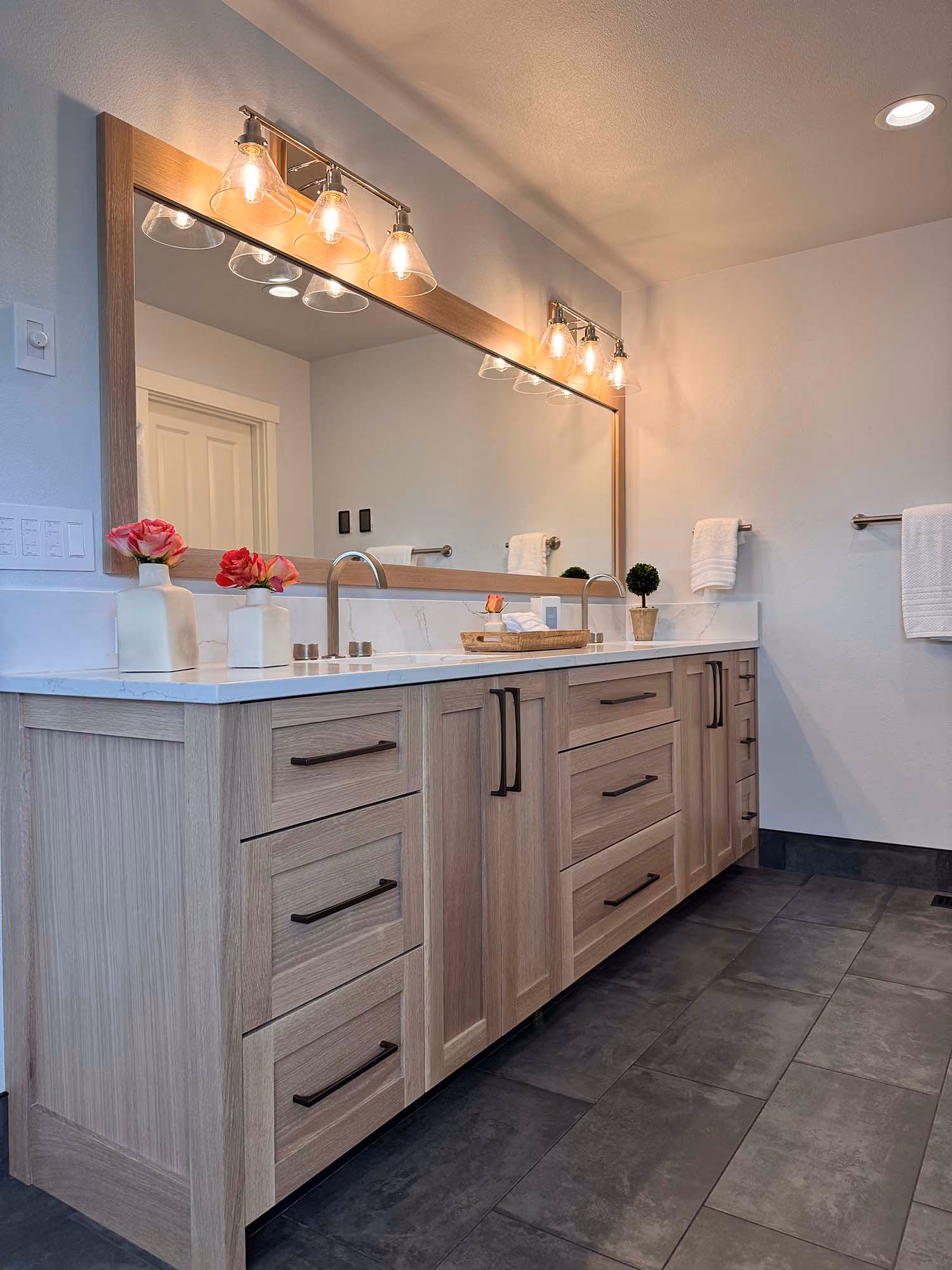 Long double-sink bathroom vanity with wall mirror and lights