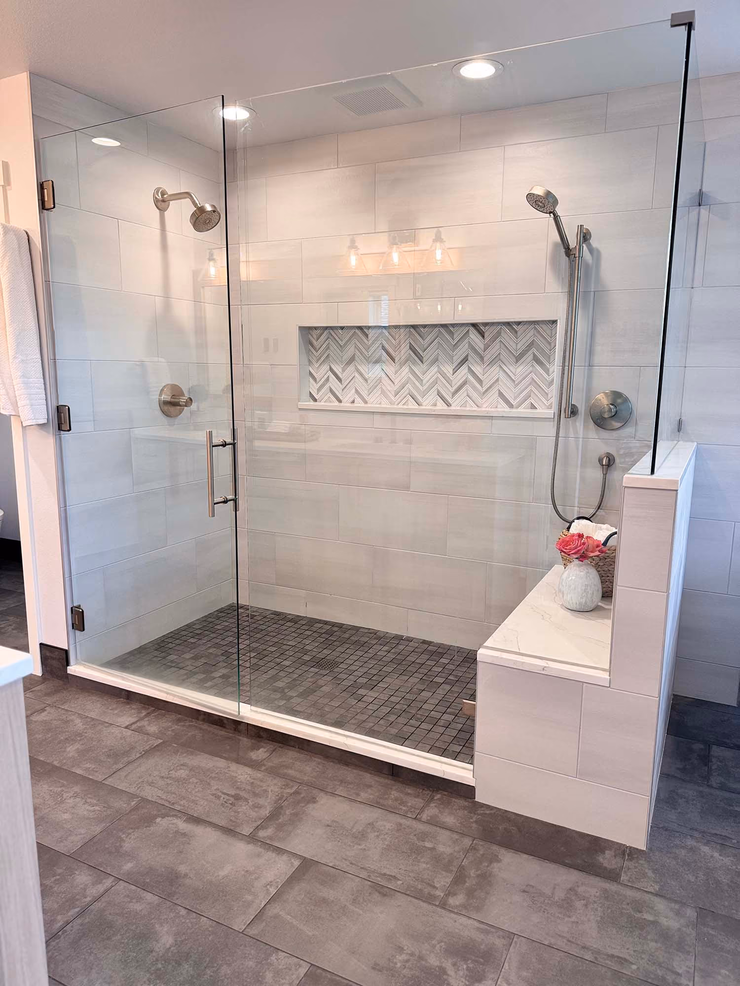Glass-enclosed walk-in shower with built-in bench