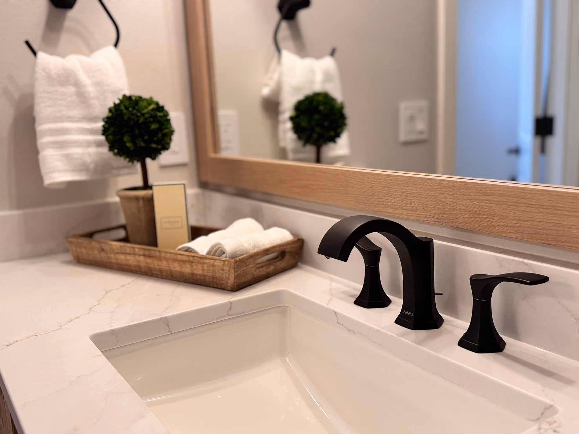 Bathroom vanity with black faucet and framed mirror
