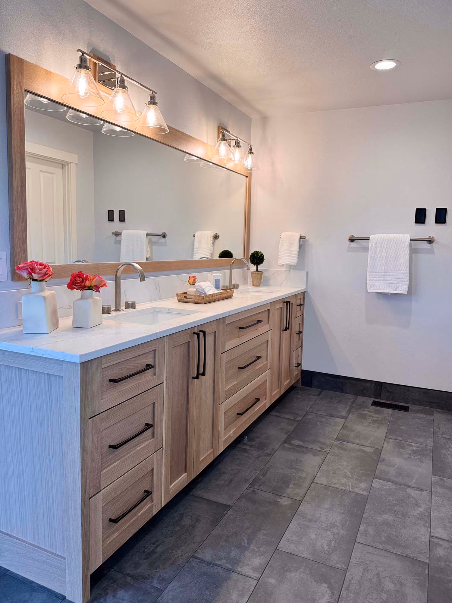 Long double-sink bathroom vanity with wall mirror and lights