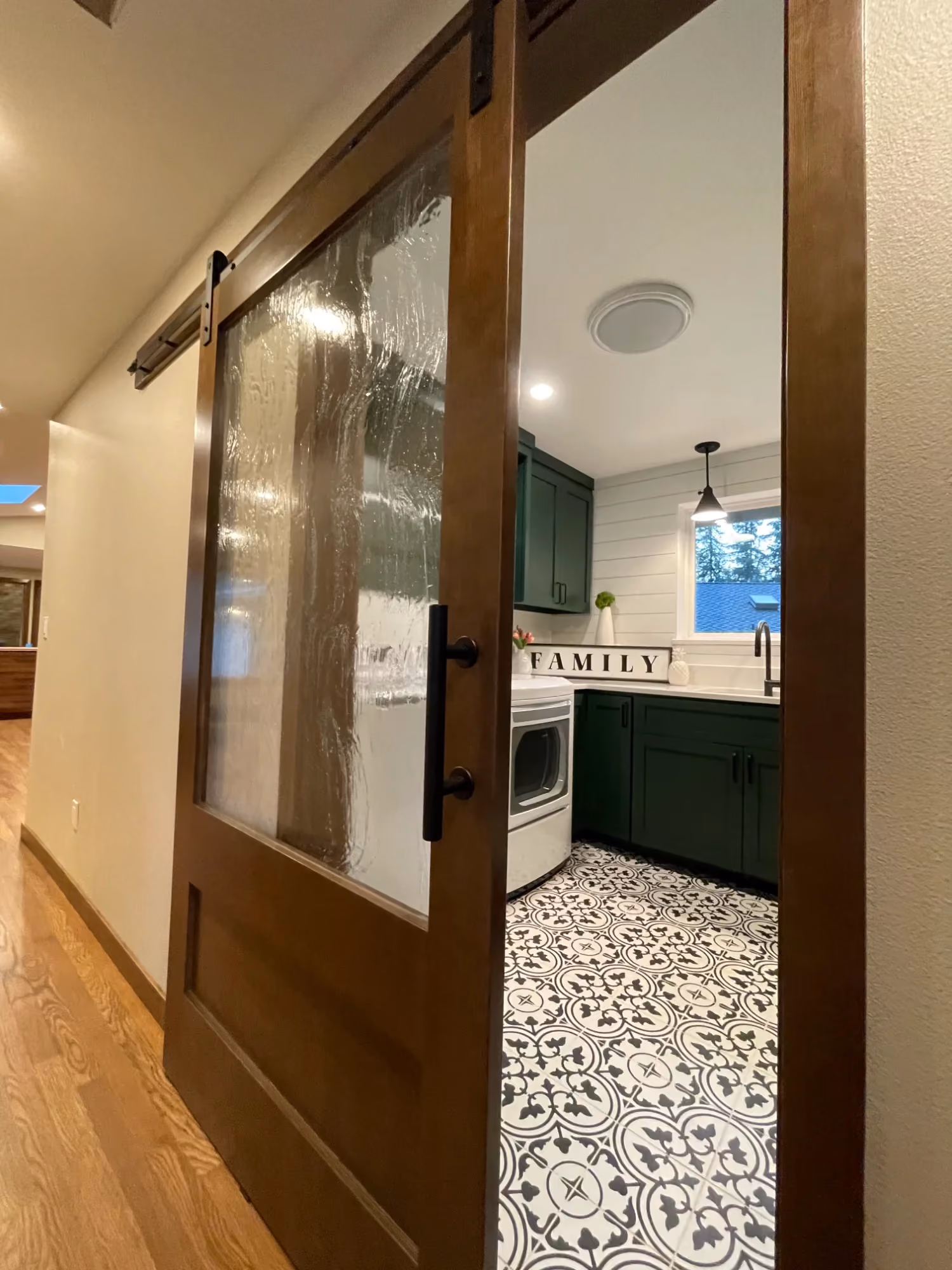 Hallway with large wall mirror and patterned floor tiles
