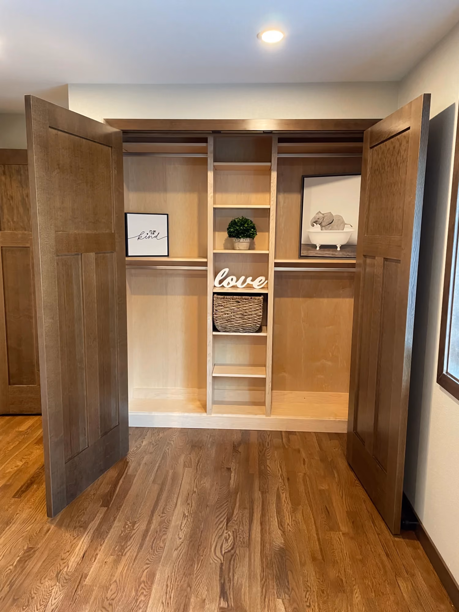 Hallway view with wood floors leading to a built-in shelving alcove