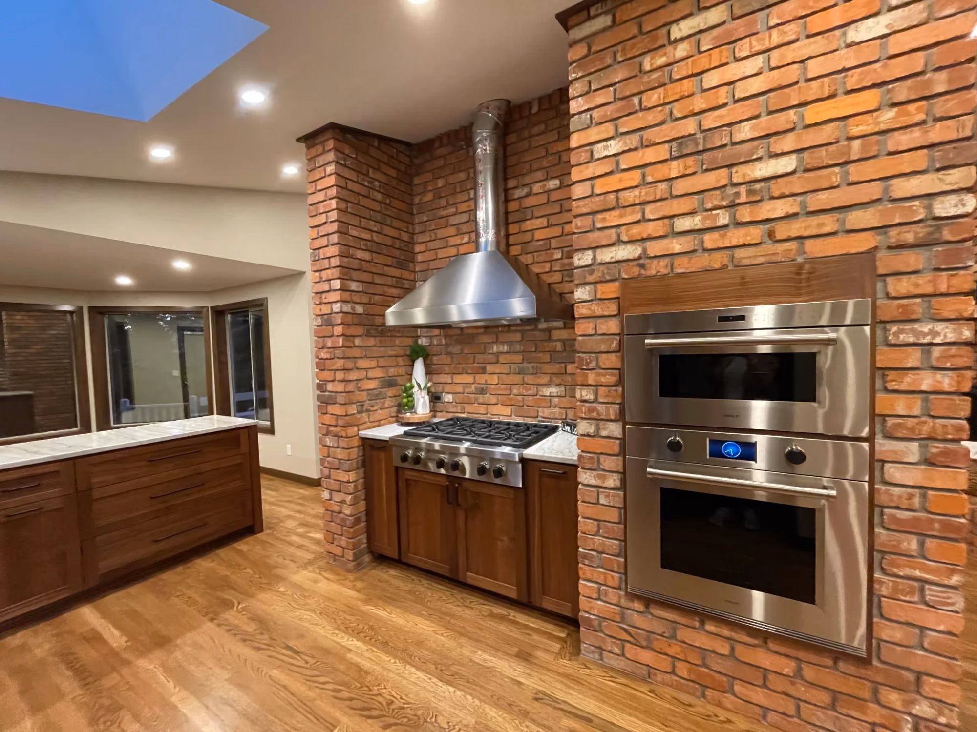 Open kitchen with brick wall and stainless appliances